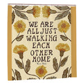 Cream shower curtain with yellow floral illustrations and Ram Dass quote 'We are all just walking each other home'.