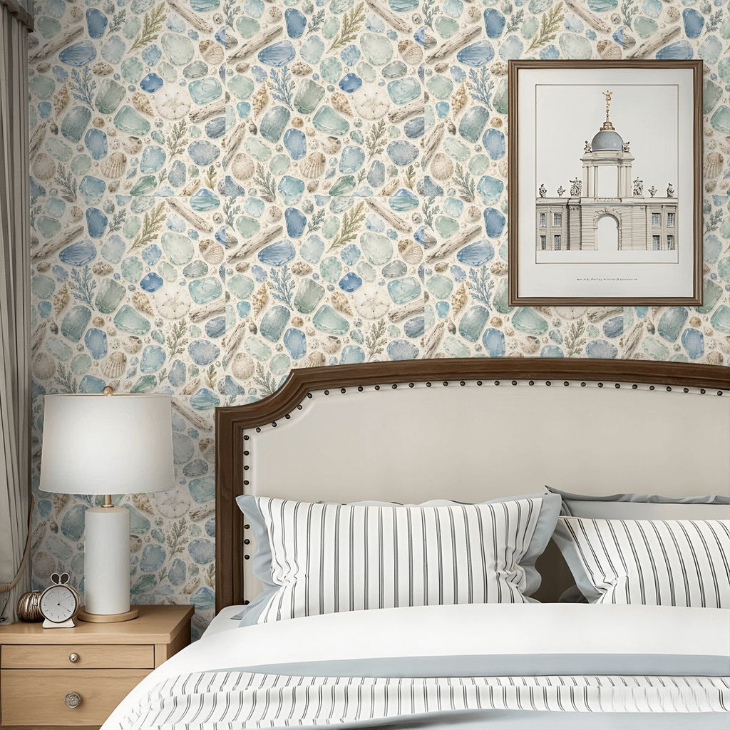 Bedroom with seashell pattern wallpaper, white headboard, and framed architectural art.