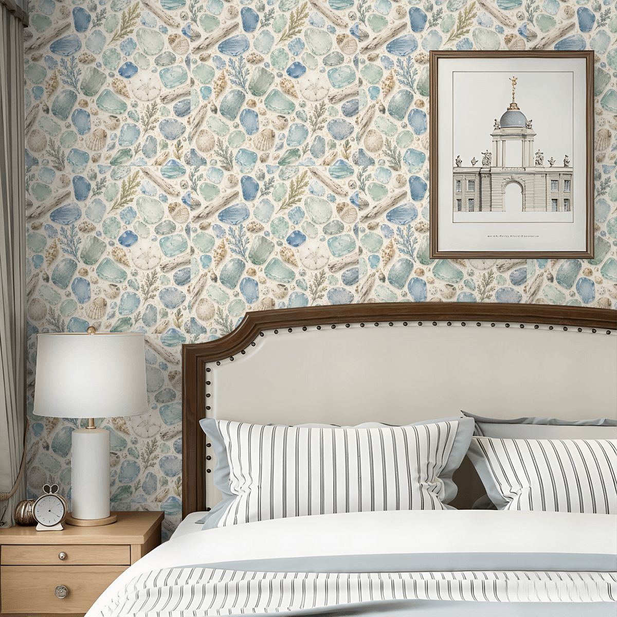 Bedroom with seashell pattern wallpaper, white headboard, and framed architectural art.