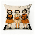 Decorative throw pillow featuring three girls in skeleton face paint holding jack-o'-lanterns.