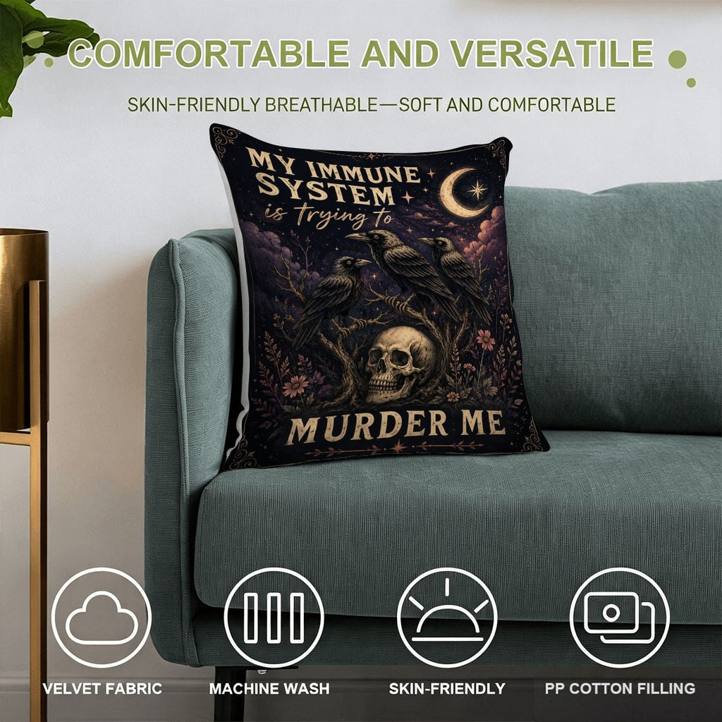 Gothic decorative pillow with skull and raven design on a teal sofa.