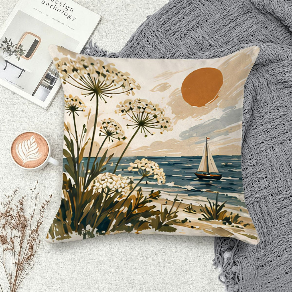 Coastal landscape throw pillow featuring white wildflowers, a sailboat, and a sunset over the ocean.