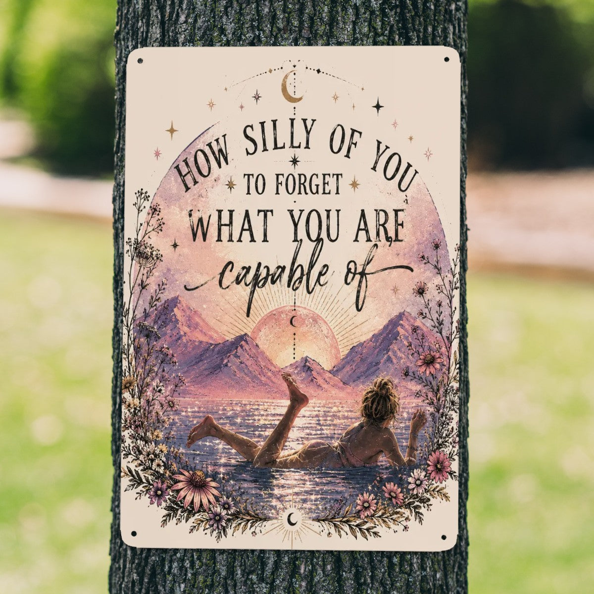 Inspirational garden flag with mountain landscape and empowering quote on a tree.
