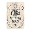 Celestial metal sign with sun, moon, and hands reading Energy Flows Where Attention Goes.