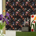 Dark floral wallpaper with vintage pink and blue roses on a black background.