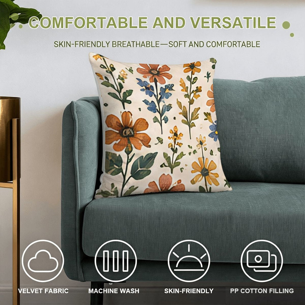 Floral patterned velvet throw pillow with orange and blue flowers on a teal sofa.
