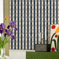 Navy blue and white striped wallpaper featuring a repeating small anchor pattern.