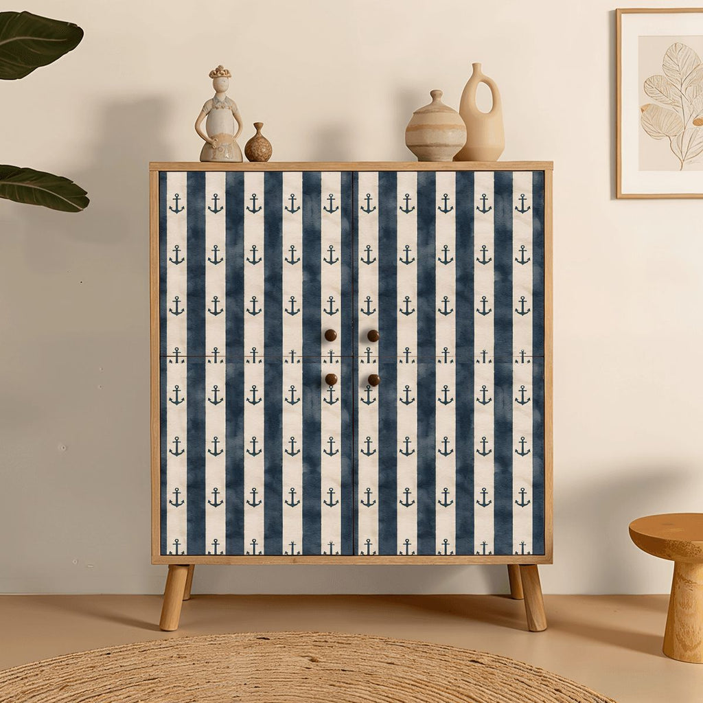Nautical striped cabinet with anchor pattern and wooden knobs in a minimalist room setting.