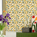 Lemon pattern wallpaper in a bright room with purple irises and modern decor.