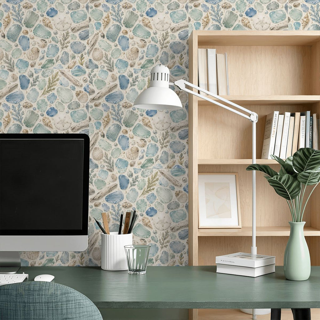 Home office desk with computer, lamp, and seashell pattern wallpaper background.