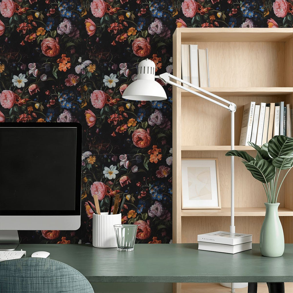Home office desk with computer, lamp, and dark floral pattern wallpaper.